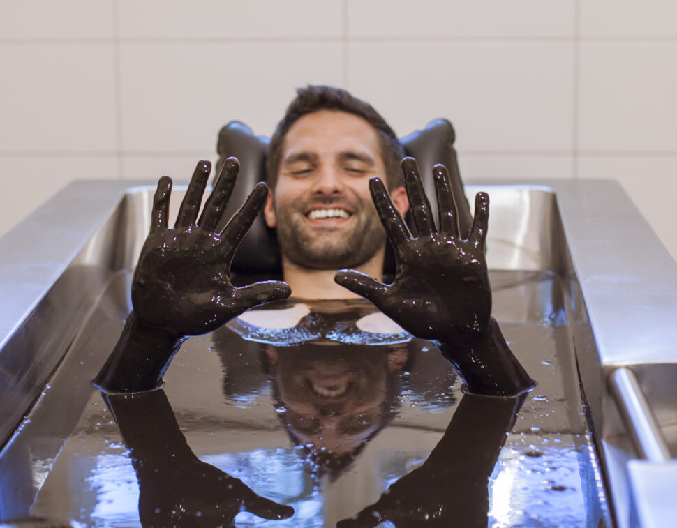 Ein Mann lächelnd in der Moorbad-Badewanne