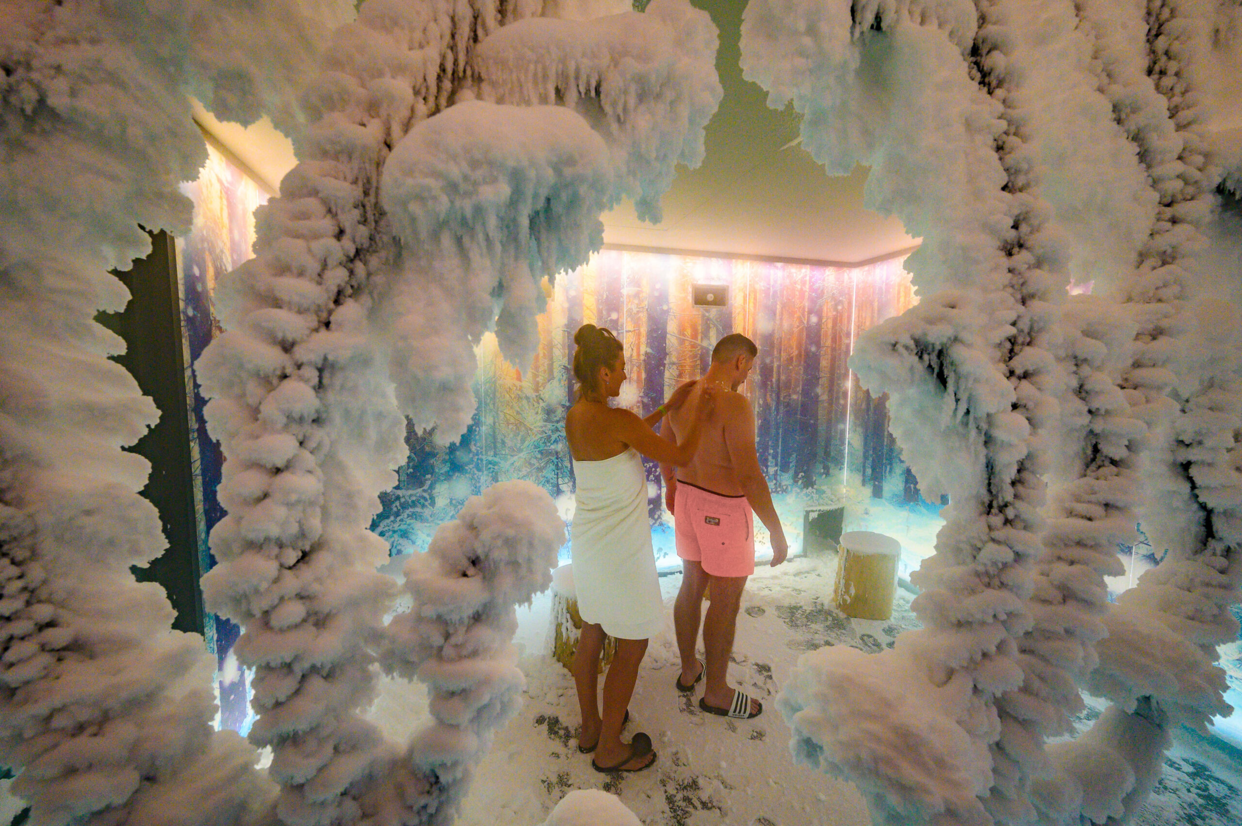 Two people are standing in the snow room at -10°C cold therapy in Bad Brambach, snow crystals can be seen in the foreground